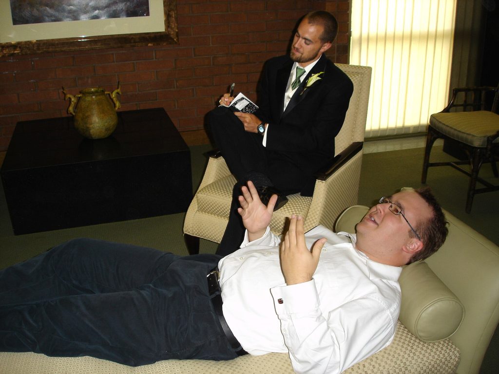 A therapist and client talking calmly during a counselling session in a soft-lit room