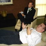 A therapist and client talking calmly during a counselling session in a soft-lit room